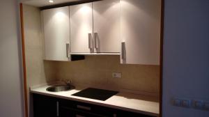 Una cocina con fregadero y gabinetes blancos. en ESTUDIO EN ZONA BAJA y Garaje Opcional, en Sierra Nevada 27 fotos más