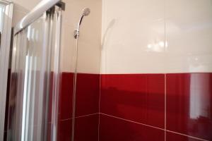 a bathroom with a shower with red and white stripes at Casa da Laurindinha in Ponte de Lima +15 photos