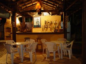 a restaurant with tables and chairs and a bar at Pousada Águas de Parati in Paraty