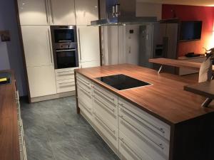 a kitchen with white cabinets and a wooden counter top at Am Kirchsteig in Schlettau