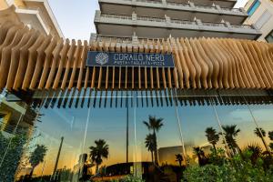 un cartel en la parte delantera de un edificio con palmeras en Coral Hotel Athens en Atenas