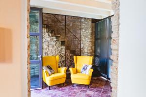 two yellow chairs and a staircase in a room at Villa Colli Storici in Desenzano del Garda