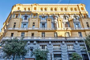 a tall yellow building with a lot of windows at Residenza Napoli Centrale in Naples