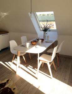 mesa de comedor blanca y sillas con ventana en The Loft, en Pilton