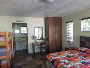 a bedroom with a bed and a desk and a sink at Kareekloof Game Farm in Derby