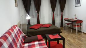 ペルミにあるManhattan Apartmentsのベッド、テーブル、ソファが備わる客室です。