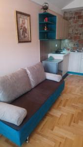 ein Sofa im Wohnzimmer mit Küche in der Unterkunft Bolonja in Užice