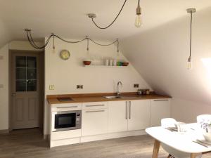 a kitchen with white cabinets and a sink at The Loft in Pilton