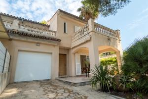 ポルト・ダルクディアにあるVilla Tamarells with garden next to Alcudia Beachの大きなガレージが目の前にある家