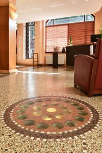 a lobby with a rug on the floor of a building at Hotel Moderne in Arras