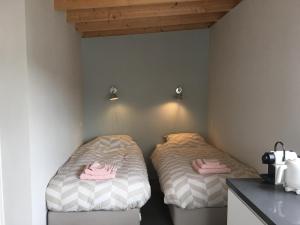 two beds in a corner of a room at Costa del Twel in Uitwellingerga