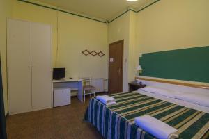 1 dormitorio con 1 cama y escritorio con ordenador en Hotel Le Grazie, en Portovenere