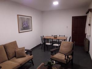 ein Wohnzimmer mit einem Sofa, einem Tisch und Stühlen in der Unterkunft Dpto San Martin in Salta