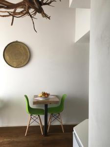 a small table and two green chairs in a kitchen at La Lanterna Camere & More in Quinto Vicentino