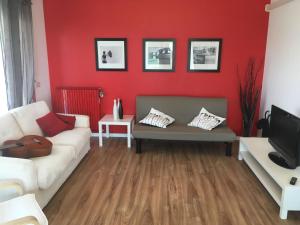 文蒂米利亞的住宿－Luminoso appartamento sul mare，客厅设有红色的墙壁和沙发