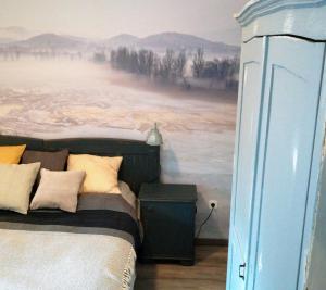 a bedroom with a bed with a painting on the wall at Postaláda vendégház in Salföld