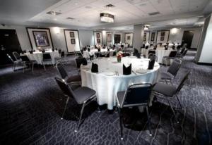 un comedor con mesas y sillas blancas en Hard Rock Hotel & Casino Biloxi, en Biloxi