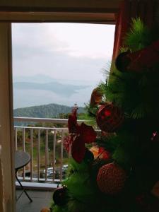 Ein Weihnachtsbaum steht vor einem Fenster in der Unterkunft Holy Family Condo at Wind Residences,Tagaytay in Tagaytay