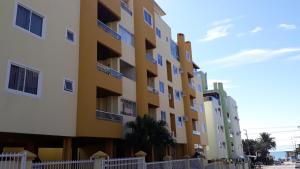 un edificio de color amarillo y blanco en Estrela do Mar B, en Bombinhas