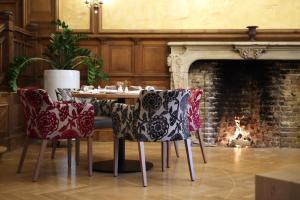 a dining room with a table and chairs in front of a fireplace at Schlosshotel Westerholt in Herten