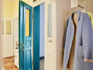 une porte bleue et un manteau suspendu dans un couloir dans l'établissement Residenz am Dresdner Stadtwald, à Dresde