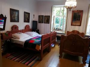 a bedroom with a bed and a chandelier at Rozmaringos Udvarház in Dunaföldvár