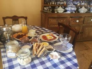 a table with breakfast food on a blue and white checked table cloth at Gemoedsrus Farm in Stellenbosch