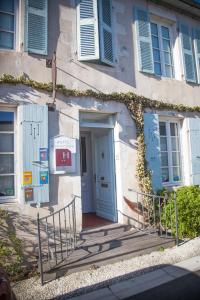 a building with blue doors and ivy on it at L'Hippocampe in La Flotte