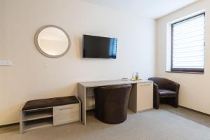 a room with a desk and a mirror and a chair at Pensiunea Select Central in Târgu-Mureş