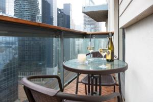 uma varanda com uma mesa e 2 copos de vinho em Royal Crossharbour Apartment em Londres