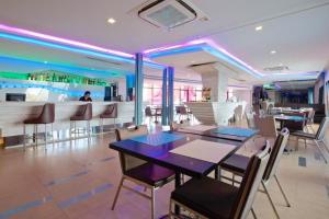 un restaurante con mesa y sillas y un bar en The Xtreme Suites, en Bangkok