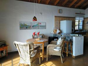cocina con mesa, sillas y nevera en La Hacienda BuenVivir - Apartamentos, en Los Llanos de Aridane