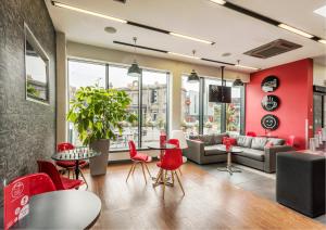 a living room filled with furniture and a large window at Haymarket Hub Hotel in Edinburgh