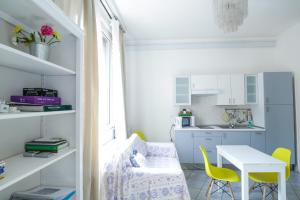 a small kitchen with a table and yellow chairs at Central cosy apartment in Bologna +6 photos
