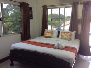 a bedroom with a bed with a large window at Saithong House in Chiang Mai