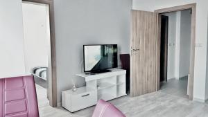 a living room with a television on a white cabinet at Apartment Valerie walking distance to Top Center in Plovdiv