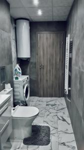 a bathroom with a toilet and a sink and a door at Apartment Valerie walking distance to Top Center in Plovdiv