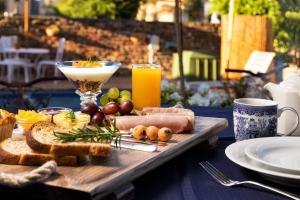 una mesa de madera con un plato de comida y un vaso de zumo de naranja en Shawheim@Hartenbos, en Hartenbos