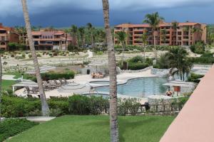 a view of a resort with a pool and palm trees at Condominios La Luna - Ocean Front in Cabo San Lucas