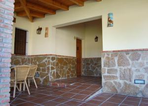 a patio with chairs and a stone wall at Residencial La Teja in Zahora