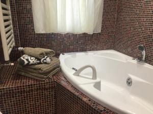 a bathroom with a tub and a sink and a towel at City Home in Verona