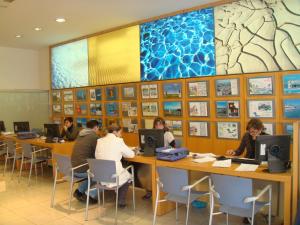 un gruppo di persone seduti ai tavoli in una biblioteca usando computer di Gemelos 20 - Beninter All Inclusive a Benidorm Altre 47 foto