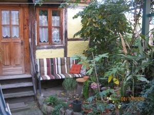 een bankje in een tuin naast een raam bij Augustinern 26 in Quedlinburg +1 foto