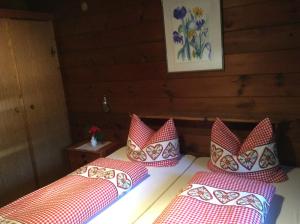 Sankt Sigmund im SellrainにあるChalet Bernsteinの赤と白の枕が備わる客室内のベッド2台