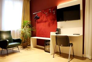 a living room with two chairs and a television at OFFICINA TESINI Guest Rooms Verona in Verona