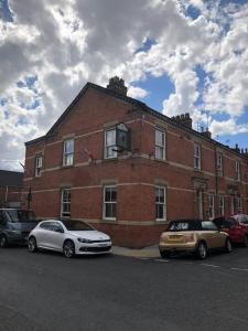 two cars parked in front of a brick building at The Leeman Rose in York