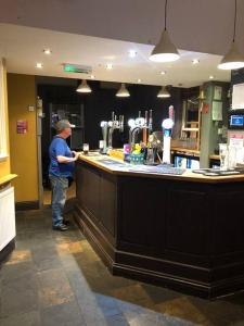 a man standing at a bar in a restaurant at The Leeman Rose in York