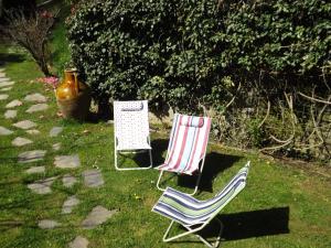 dwa krzesła siedzące na trawie na dziedzińcu w obiekcie Guest house Cascina Belsito w mieście Biella