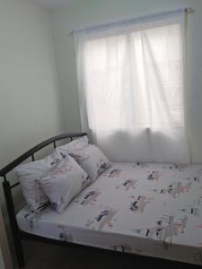 a bed with pillows on it with a window at Stay at Sanremo Oasis Cebu in Cebu City
