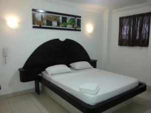 een bed met twee kussens in een kamer bij Hotel Pension Corona in Panama-Stad